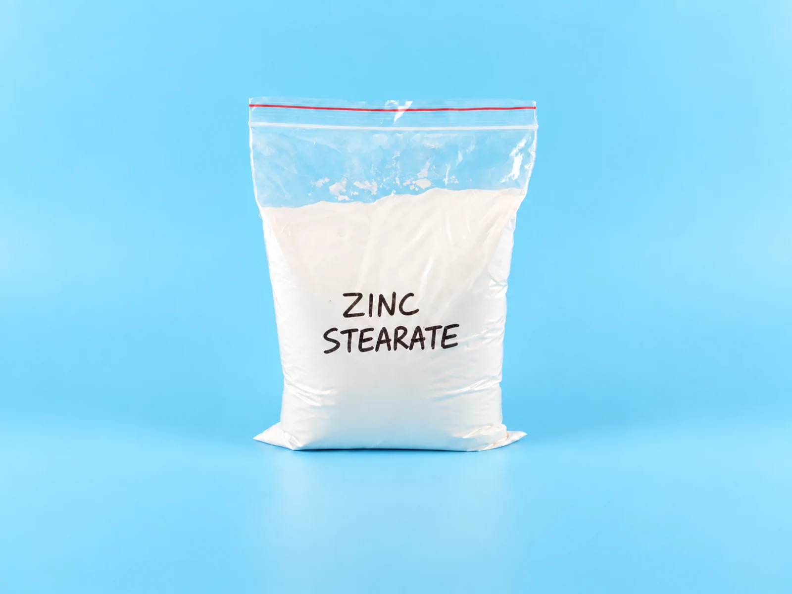 Zinc stearate white powder sample in a laboratory dish